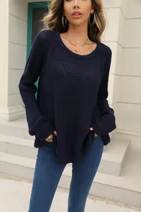 Close-up detail of a dark blue long sleeve knit sweater featuring a textured rib pattern