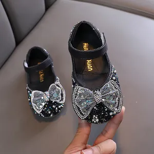 Scarpette nere da principessa per bambina con un grande fiocco di paillettes e perle.