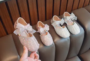 Detail von Mädchen Prinzessinnenschuhen mit Perlen, Strass und Schleifen in Rosa und Weiß.