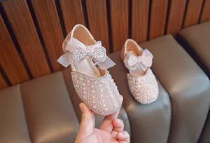 Detailansicht von rosa Mädchen-Prinzessin-Schuhen mit Strasssteinen, Perlen und Schleife.