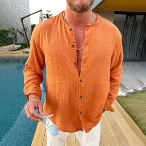Detail view of men's orange crinkle texture long sleeve shirt with stand collar in lifestyle setting