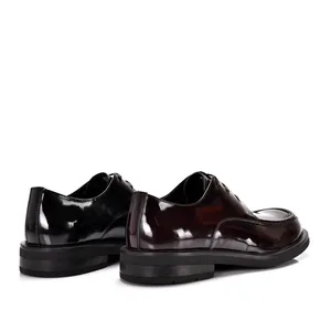 Detailansicht glänzender Herren-Lederschuhe mit Karree-Spitze und dicker Sohle.