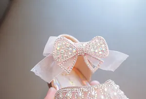 Detailaufnahme einer mit Strass besetzten Schleife an rosa Prinzessinnenschuhen