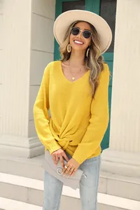 Détail du pull en maille jaune col en V avec élégant nœud torsadé sur le devant