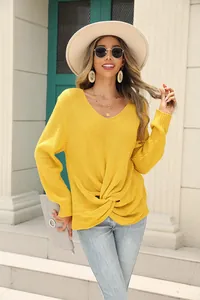 Détail élégant d'un pull en maille jaune à col en V avec un nœud torsadé devant
