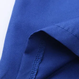 Macro view of royal blue twill fabric texture and reinforced stitching on workwear garment
