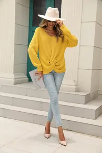 Détail d'un pull en maille jaune à col en V avec un nœud frontal élégant
