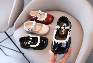 Macro view of girls black patent leather princess shoes with pearls and lace trim