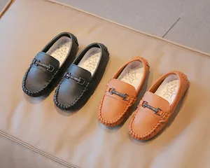 Detail view of boys' leather loafers featuring classic horsebit and pebble texture