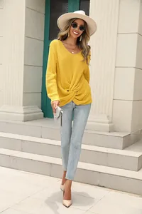 Vue détaillée d'un pull en maille jaune à col en V avec un nœud torsadé élégant