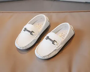 Close-up detail of white British style toddler loafers featuring a vintage metal buckle