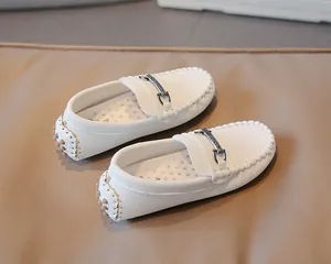 Close-up detail of white breathable British style loafers for boys with metal buckle.