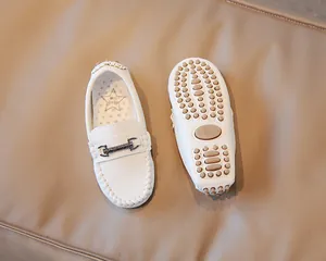 Detail view of white children's loafers with premium textured leather and pebble rubber sole