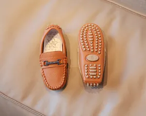 Detailed view of orange-brown children's loafers with textured leather and anti-slip sole