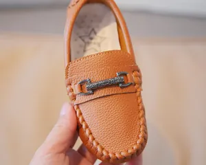 Detailed view of tan leather toddler loafer with vintage metal buckle and stitching
