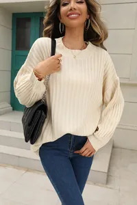 Gros plan sur un élégant pull en maille côtelée crème avec un col rond classique