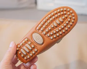 Macro detail of children's leather loafer sole featuring anti-slip rubber pebbles