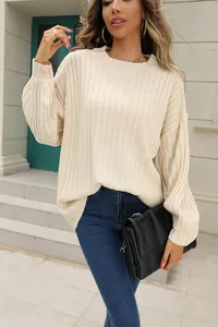 Détail du pull élégant en maille côtelée crème pour femme, vue extérieure lifestyle