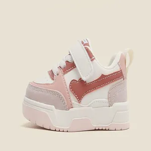 Side detail view of pink and white toddler sneakers featuring soft sole and heart design