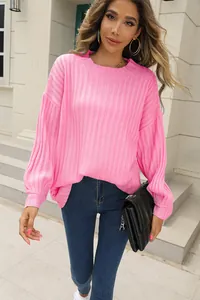 Vue lifestyle d'un pull en maille côtelée rose vif avec une coupe ample oversize.