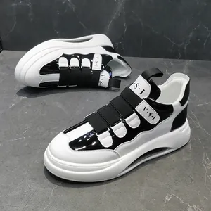 Schwarz-weiße klobige Plateau-Sneaker mit dekorativen elastischen Riemen auf Marmor