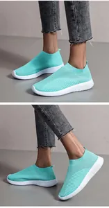 Macro view of light blue breathable knit sneakers with flexible white sole