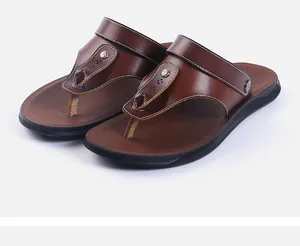 Detailed view of brown leather men's flip-flops with metallic rivets and white stitching