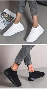 Detailed macro view of white and black breathable fly-knit slip-on sneakers