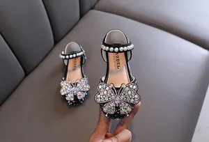 Detailed view of the sparkling rhinestone butterfly on these black girl's princess shoes