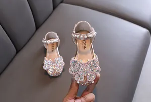 Close-up of pink girls' princess shoes with sparkling butterfly rhinestone detail