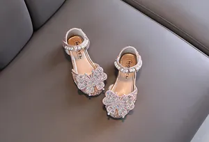 Detailed macro view of pink girls princess shoes with rhinestone butterfly and pearl strap