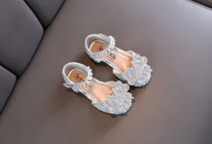 Detailed view of silver glitter girl's princess shoes with crystal butterfly