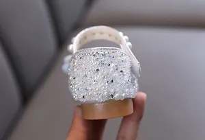Detailed view of silver girl's princess shoe heel decorated with rhinestones and pearls