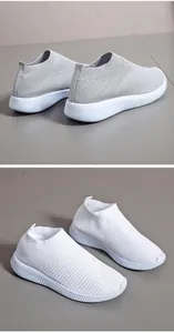 Macro view of grey and white fly-knit breathable sneakers with elastic slip-on design