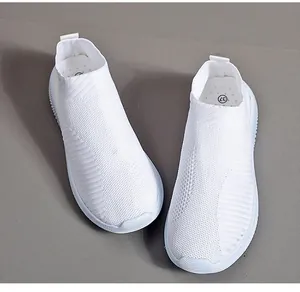 Detail view showing the breathable texture of white flyknit slip-on sneakers for women