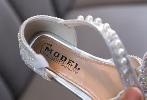 Close-up of silver girls' princess shoe with pearl strap and rhinestone details
