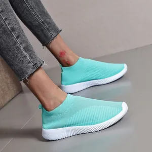 Breathable turquoise flying knit slip-on sneakers with white ribbed flat soles.