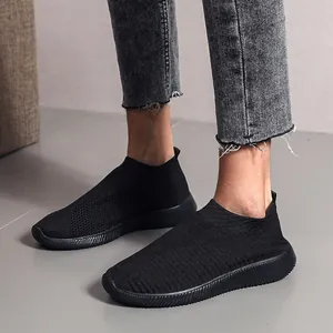 Comfortable breathable black knitted slip-on sneakers with flat rubber soles for casual wear