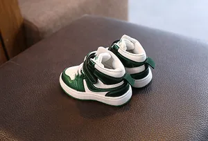 Détail de baskets montantes pour enfants vert et blanc sur surface cuir