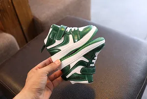 Vue détaillée de baskets montantes pour enfants vertes et blanches au fini cuir verni brillant.