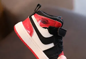 Vue rapprochée de baskets montantes rouges et noires pour enfants avec patte auto-agrippante