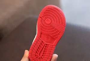 Vue macro détaillée de la semelle extérieure en caoutchouc rouge pour baskets hautes enfants