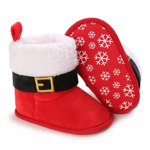 Detalle de botas navideñas rojas para bebé con ribete de piel blanca y suela de nieve