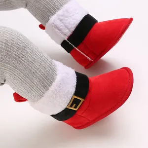 Primer plano de botas de Navidad para bebé en algodón rojo con ribete de pelo