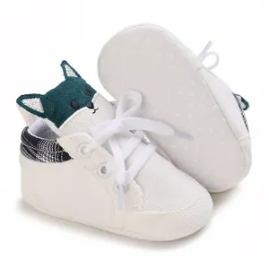 Vista detallada de zapatos blancos para bebés con un lindo diseño de animal verde