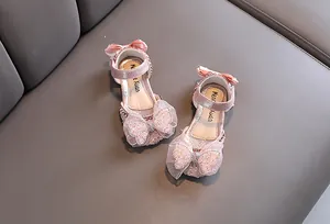 Gros plan de chaussures princesse rose pour fille avec nœud brillant et strass