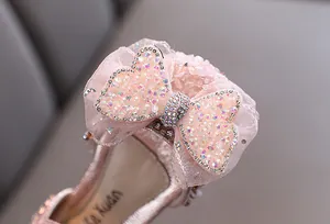 Gros plan de chaussures de princesse roses pour filles avec un nœud en strass brillant