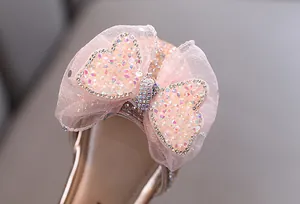 Close-up of pink mesh bow with heart rhinestones on girls' princess dress shoes