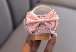 Vue détaillée d'une chaussure de princesse rose pour fille avec nœud en satin et cristal
