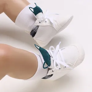 Primer plano de zapatos blancos para bebé con bonitas orejas de gato en verde